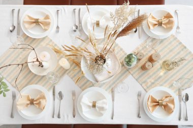 Kurumuş çiçekler, mumlar ve tabaklar ile zarif bir masa.