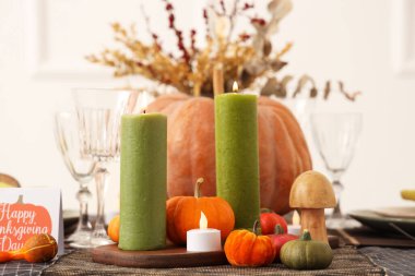 Şükran Günü için balkabakları, tebrik kartları ve yanan mumlarla şenlik masası.