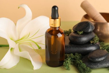 Gerekli yağ şişesi, spa aksesuarları ve zambak çiçeğiyle renklendirilmiş, yakın plan