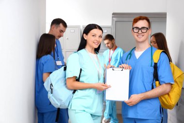 Üniversite binasında panosu olan tıp öğrencileri.