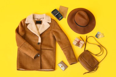 Sarı arka planda şık kadın ceketi, aksesuar ve kredi kartı kompozisyonu