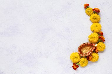 Beyaz arka planda kadife çiçekleri olan Diya lambası. Divaly kutlaması