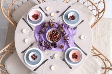 Okaliptüs dalları, kestaneler ve yanan mumlarla sonbahar sofrası.