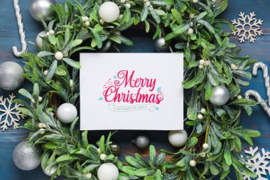 Mavi ahşap arka planda tebrik kartı ve dekoru olan güzel bir Noel kompozisyonu
