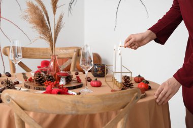 Şükran Günü yemeği için yemek masasını dekore eden kadın.