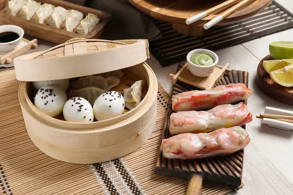 Delicious Chinese dishes on light wooden table, closeup
