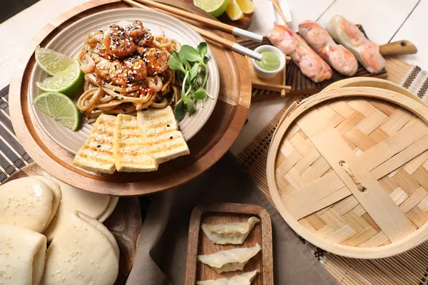 stock image Different Chinese dishes on light wooden table, closeup