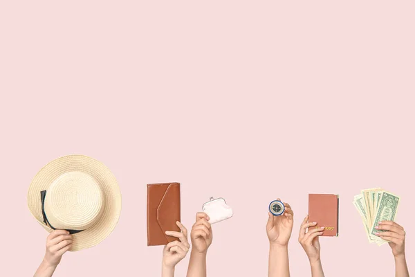 Female hands with hat, wallets, compass, passport and money on beige background. Travel concept