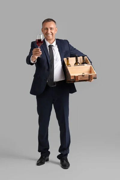 Reifer Mann Mit Glas Und Schachtel Weinflaschen Auf Hellem Hintergrund — Stockfoto