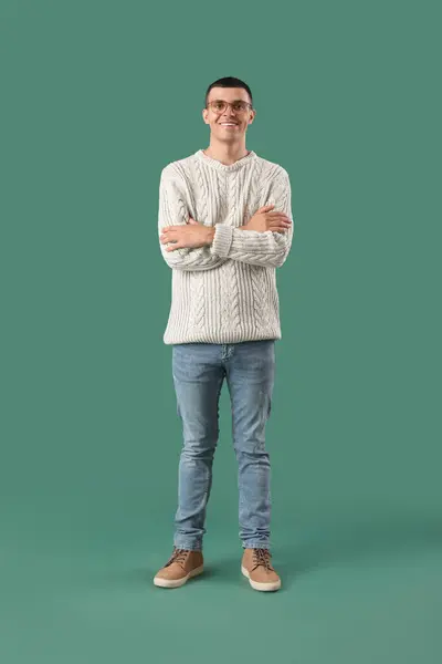 緑の背景に編まれたセーターの若い男 — ストック写真