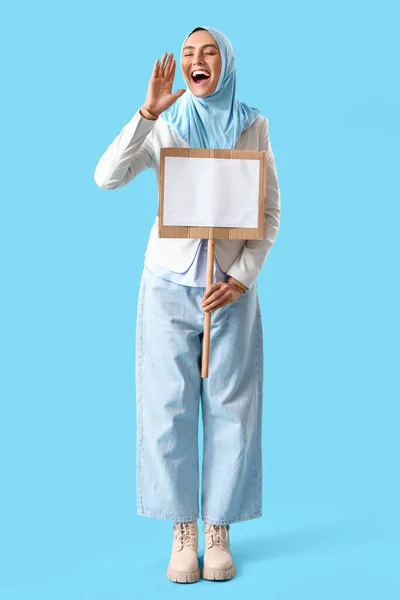 Stilvolle Muslimin Mit Leerem Brett Auf Blauem Hintergrund — Stockfoto