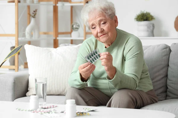 Senior woman with pills at home