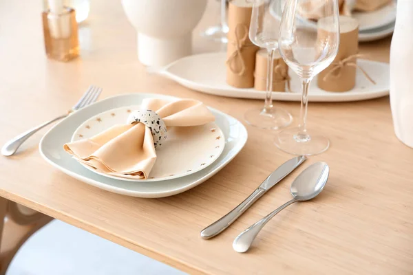 Elegant table setting with cutlery, glasses and folded napkin, closeup