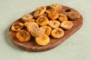 Tahta tahta, yeşil arka planda kurutulmuş incir.