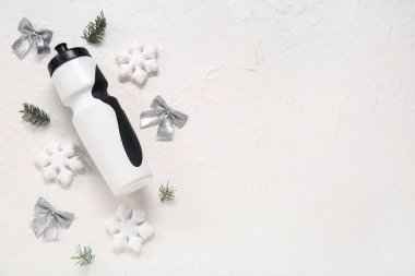 Arka planda spor şişesi ve Noel süslemeleri olan kompozisyon