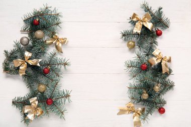 Köknar dalları ve beyaz ahşap arka planda güzel Noel süslemeleri olan kompozisyon
