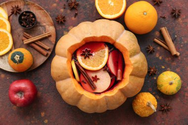 Kahverengi arka planda balkabağında lezzetli sıcak şarapla güzel bir kompozisyon.