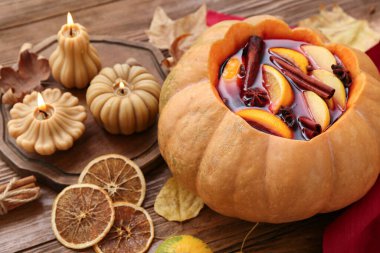 Ahşap arka planda balkabağında lezzetli sıcak şarapla güzel bir kompozisyon.