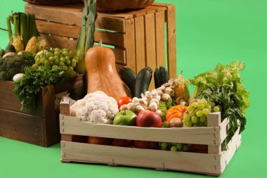 Yeşil arka planda taze sebzeli kutular