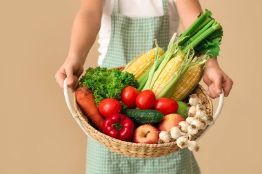 Bej arka planda taze yiyeceği olan küçük çiftçi, yakın plan.