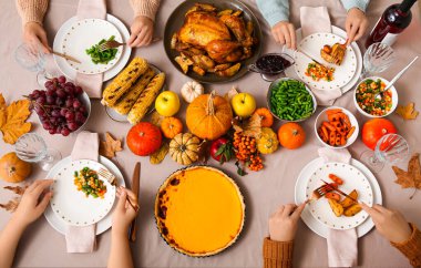 Yemek masasında lezzetli yemekleri olan kadınlar Şükran Günü için sette.