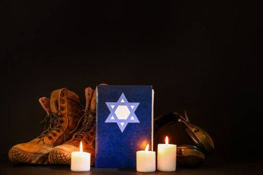 Tevrat 'ta yanan mumlar ve karanlık arka planda askeri mühimmat.