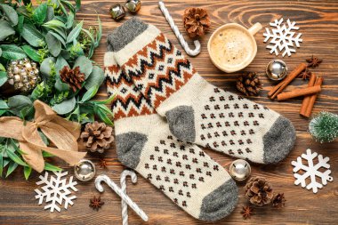 Noel dekorlu sıcak çoraplar ve ahşap arka planda bir fincan kahve.