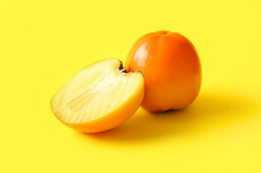 Sarı arka planda taze olgun hurma.