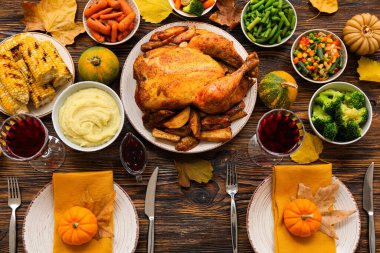 Koyu ahşap arka planda Şükran Günü için balkabağı ve lezzetli yemekler.