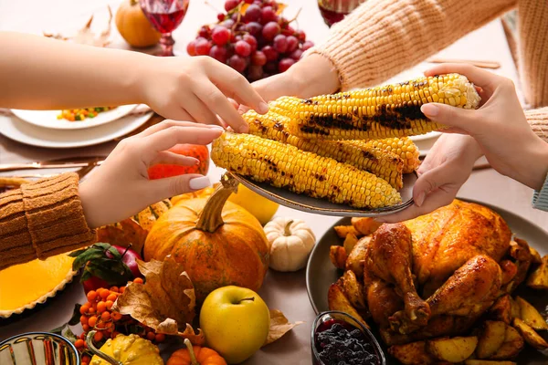 Women with tasty food at dining table set for Thanksgiving Day, closeup