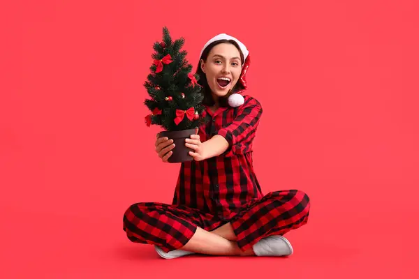 Gyönyörű Fiatal Pizsamában Mikulás Kalap Karácsonyfa Piros Háttér — Stock Fotó