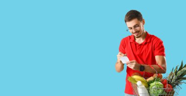 Ürün listesi ve açık mavi arka planda alışveriş sepeti olan ve metin için yeri olan bir adam