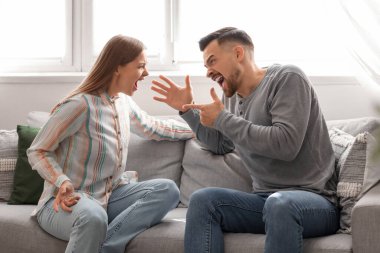 Kızgın genç çift evde kavga ediyor. Aile içi şiddet kavramı