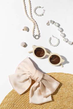 Güneş gözlüklü mücevherler ve beyaz arka planda yaz şapkası, yakın plan.