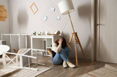 Deprem sırasında evde masanın yanında oturan genç bir kadın.