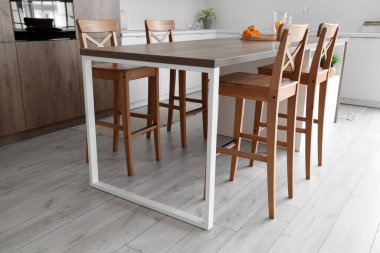 Hafif mutfağın içinde ahşap masa ve sandalyeler.