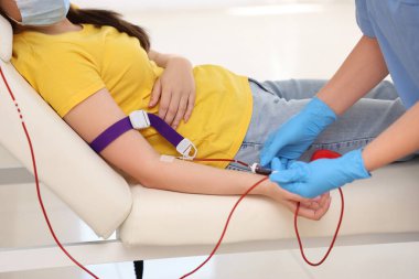 Klinikte genç donörden kan alan kadın hemşire.