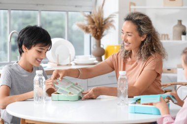 Anne ve küçük oğlu mutfakta öğle yemeği hazırlıyorlar.