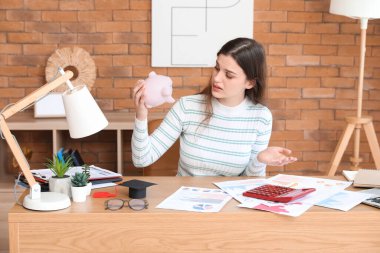 Boş kumbarası olan hoşnutsuz bir kız öğrenci. Öğrenci kredisi kavramı