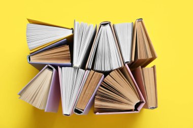 Sarı arkaplan üzerine birçok yarı açık kitap