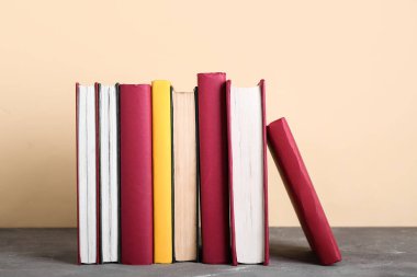 Bej arkaplana karşı gri masadaki kitaplar