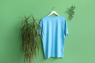 Yeşil arka planda asılı şık mavi tişört