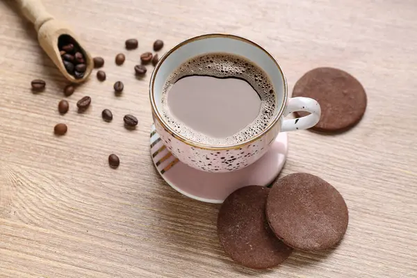 Drink coaster with cup of coffee and cookies on wooden table