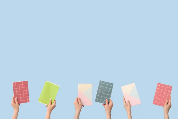 stock image Hands with notebooks on blue background