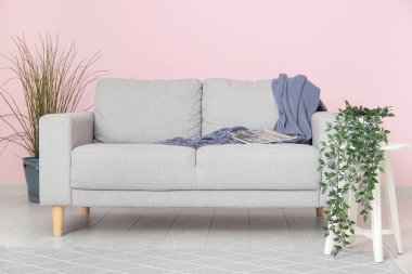 Gri kanepesi, çiçekleri ve çiçekleri olan şık bir oturma odası.