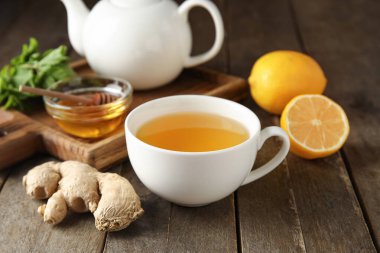 Bir fincan zencefilli çay ve bal, ahşap zemin üzerinde.