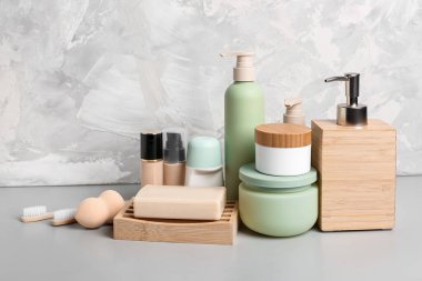 Grunge arka planında farklı kozmetik ürünleri, diş fırçaları ve makyaj süngeri