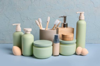 Renkli arka planda farklı kozmetik ürünler, diş fırçaları ve makyaj süngerleri