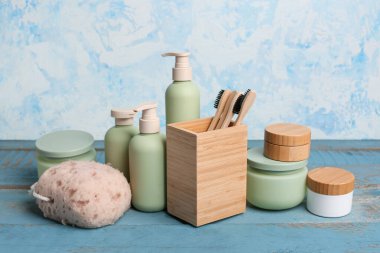 Renkli ahşap masa üzerinde kozmetik ürünler ve banyo malzemeleri.