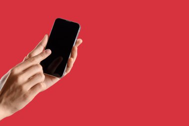 Kırmızı arkaplanda boş cep telefonu olan kadın